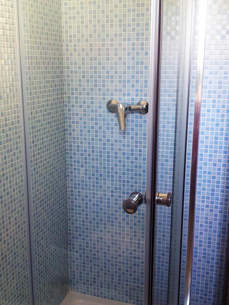 une salle de bain avec douche aux carreaux bleus dans l'établissement Hotel Rodian, à Acquappesa
