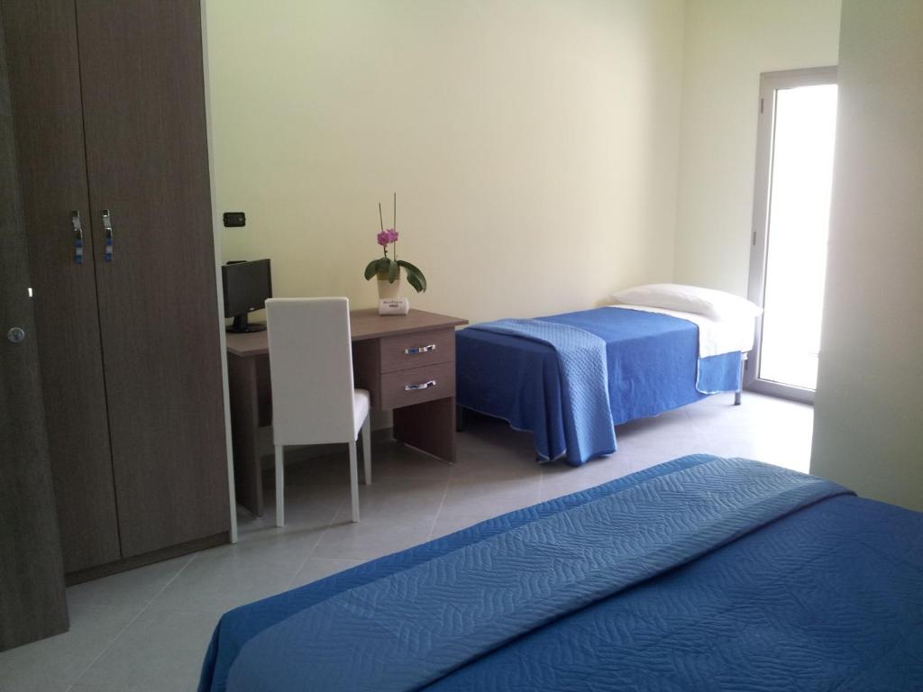une chambre avec deux lits et un bureau avec un ordinateur dans l'établissement Hotel Rodian, à Acquappesa