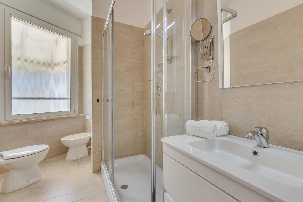 une salle de bain avec toilettes, lavabo et douche dans l'établissement Hotel Austria, à Caorle