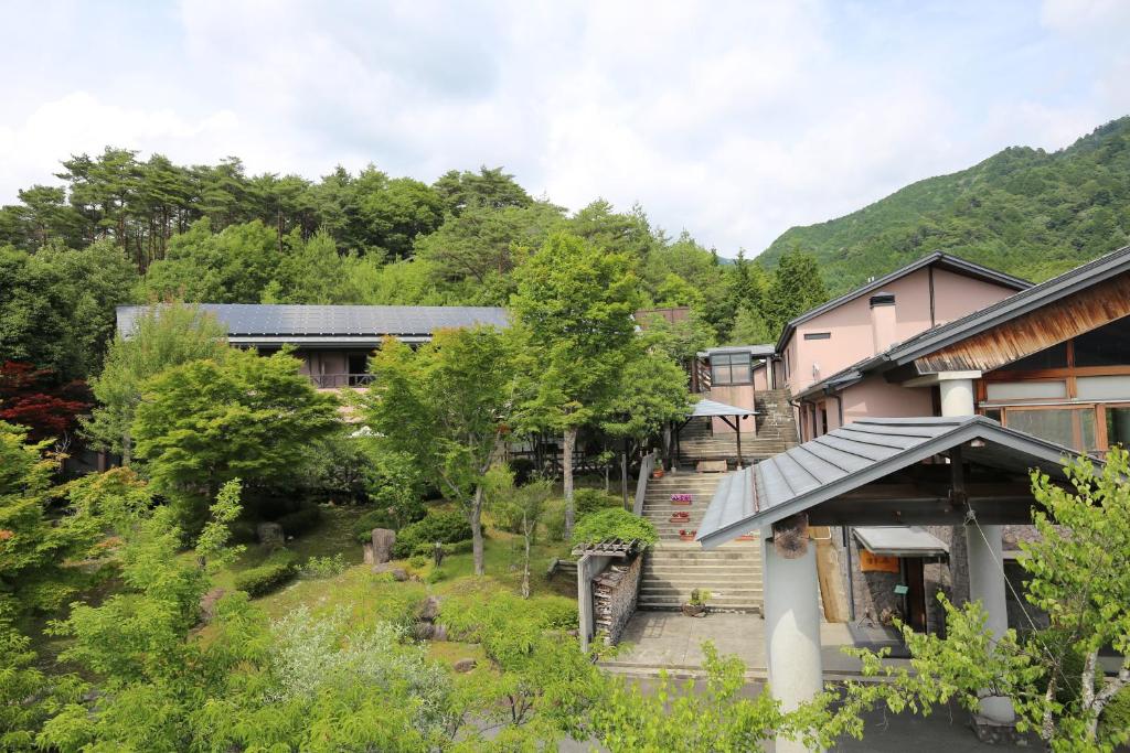- une vue sur une maison avec des arbres et des bâtiments dans l'établissement Hotel Fuki no Mori, à Nagiso