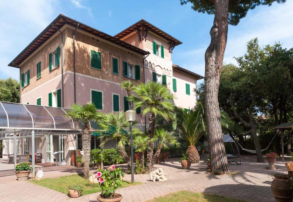 un bâtiment avec des palmiers devant dans l'établissement Albergo Battelli Only Adults, à Marina di Pietrasanta