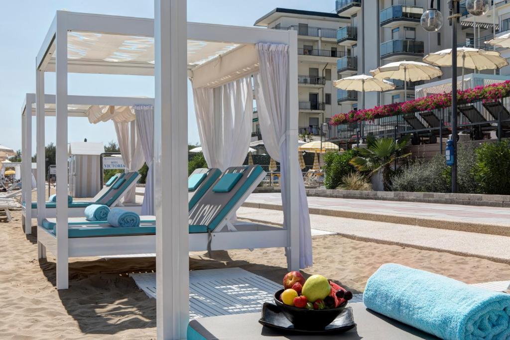 quelques chaises sur une plage avec un bol de fruits dans l'établissement Victoria Frontemare Beach & Spa Hotel Jesolo, à Lido di Jesolo