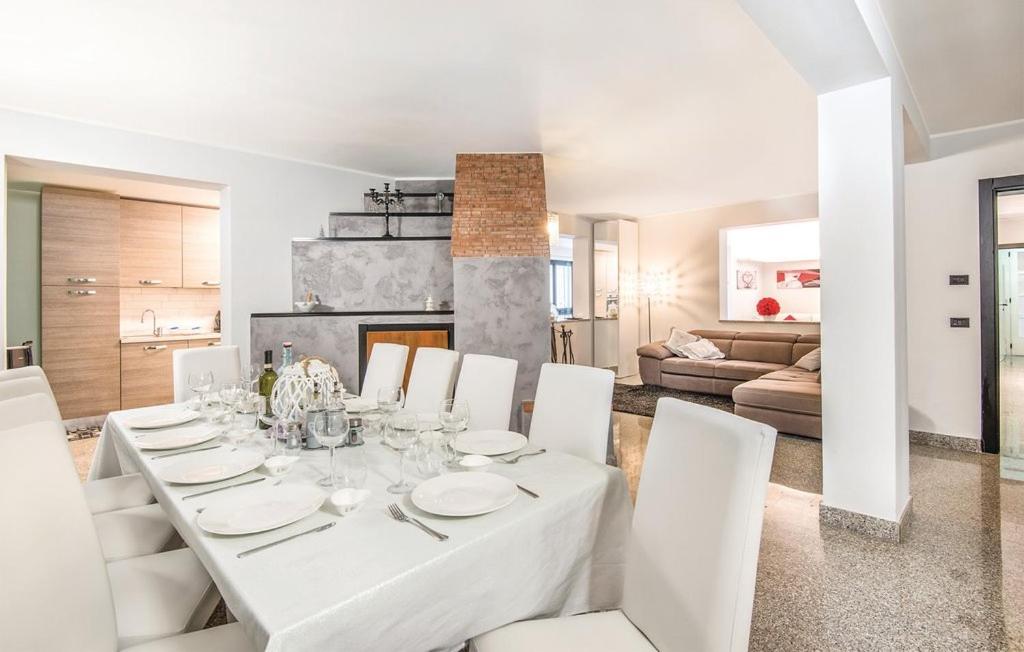 une salle à manger blanche avec une table blanche et des chaises blanches dans l'établissement Villa Serena, à Assise