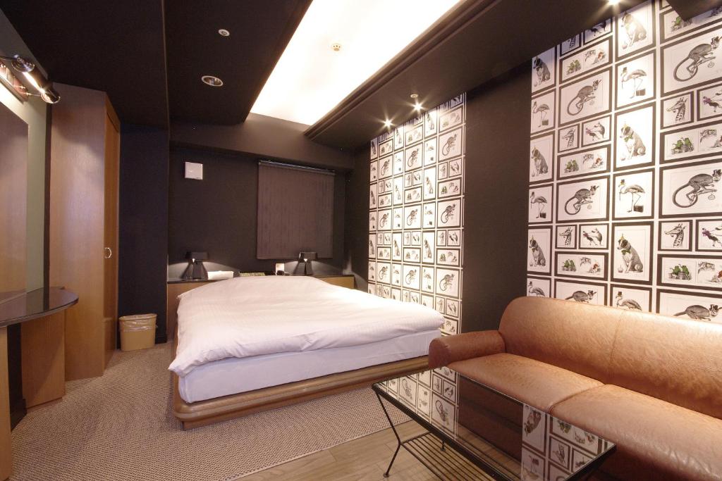 une chambre avec un lit et un canapé dans l'établissement Hotel Rio (Adult Only), à Sapporo