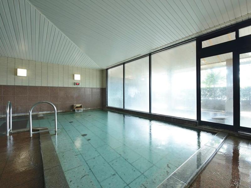 une piscine vide dans un immeuble avec des fenêtres dans l'établissement Hotel Suimeikan, à Yamanouchi 14 autres photos