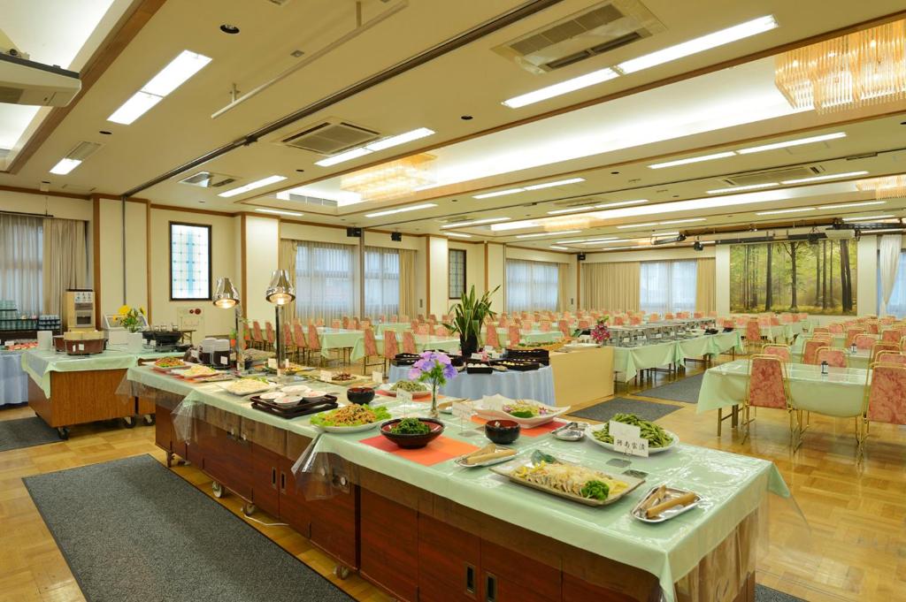 une grande salle de banquet avec des tables où vous pourrez manger dans l'établissement Hotel Suimeikan, à Yamanouchi
