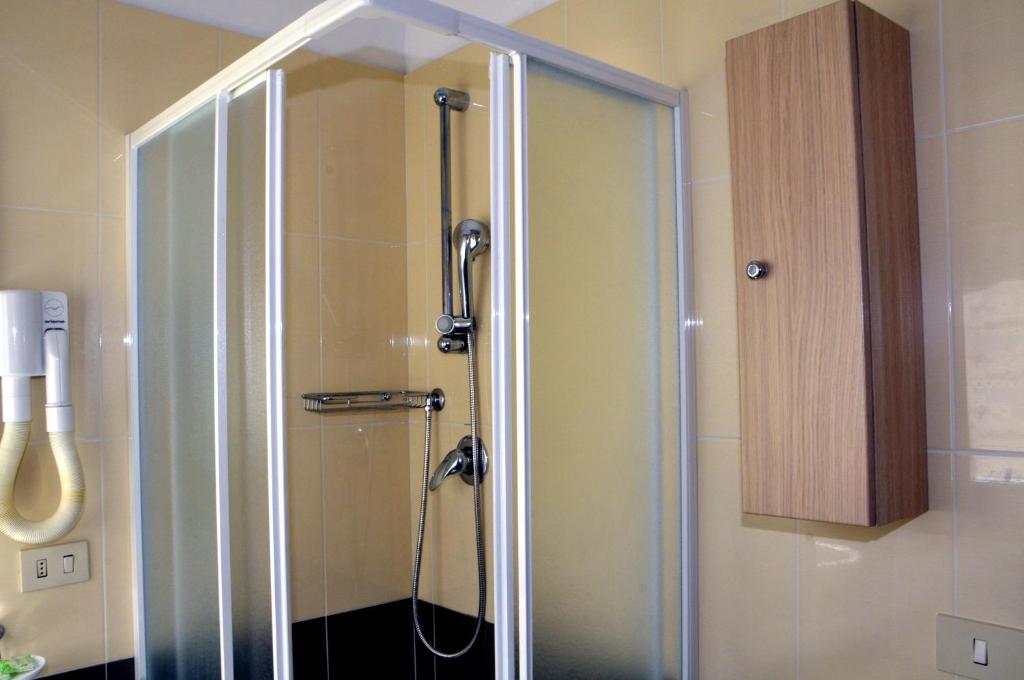une douche avec une porte vitrée dans une salle de bain dans l'établissement Hotel Levante, à Cervia 33 autres photos
