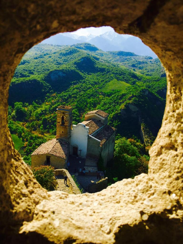 - une vue sur un bâtiment depuis un trou dans une montagne dans l'établissement Hotel Claila, à Francavilla al Mare
