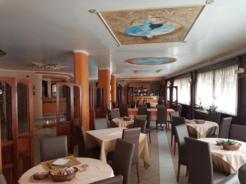 un restaurant avec des tables et des chaises et un plafond dans l'établissement Hotel Nautilus, à Nicotera Marina