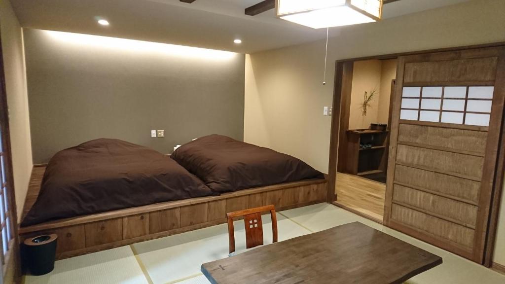 une chambre avec un lit et une table en bois dans l'établissement Kurokawa Onsen Ryokan Ichinoi, à Minamioguni