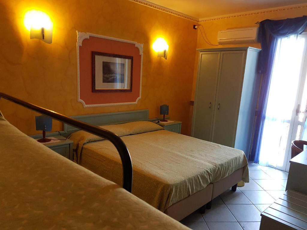une chambre d'hôtel avec deux lits et une fenêtre dans l'établissement Hotel Nautilus, à Nicotera Marina