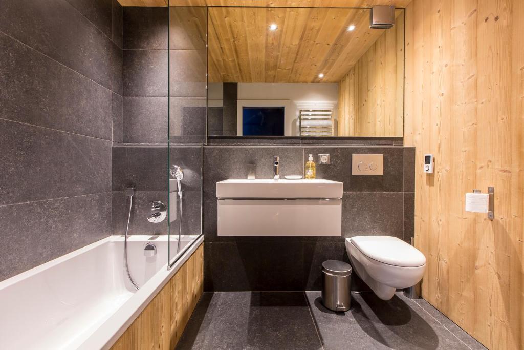 une salle de bain avec toilettes, lavabo et baignoire dans l'établissement Appartement Le Danay 10 personnes, au Grand-Bornand