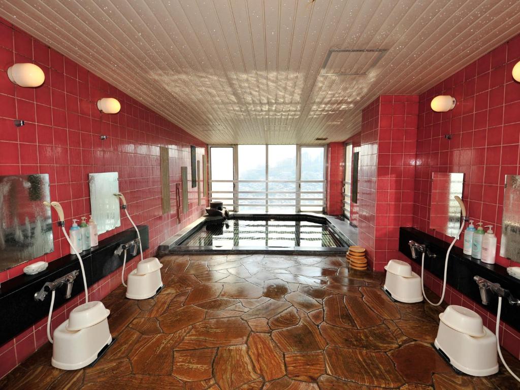 La salle de bains est pourvue de 3 lavabos et de carrelage rouge. dans l'établissement Nisshokan Bettei Koyotei, à Nagasaki