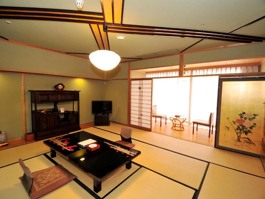 - un salon avec une table au milieu dans l'établissement Nisshokan Bettei Koyotei, à Nagasaki
