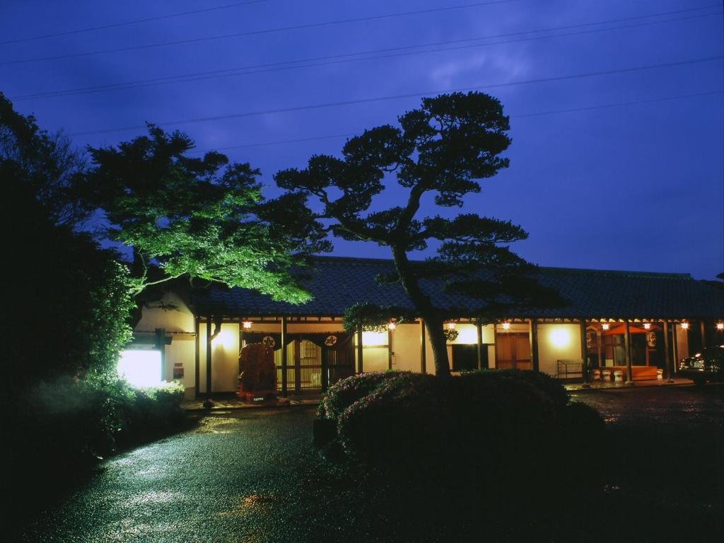 un bâtiment avec un arbre devant lui la nuit dans l'établissement Nisshokan Bettei Koyotei, à Nagasaki
