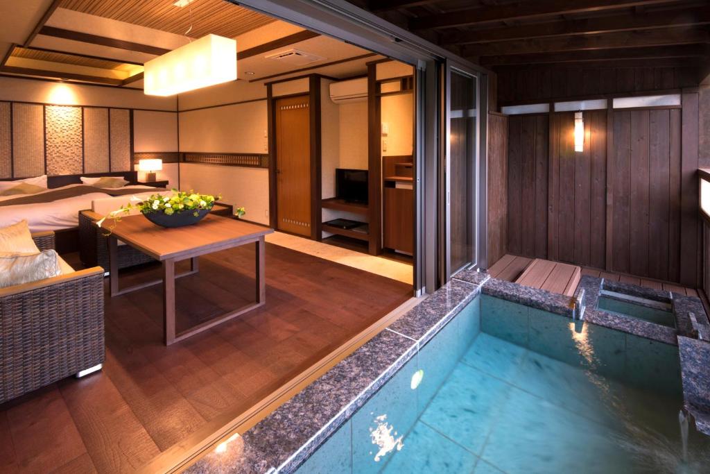 une chambre d'hôtel avec un bain à remous et une chambre dans l'établissement Uminohana, à Atami