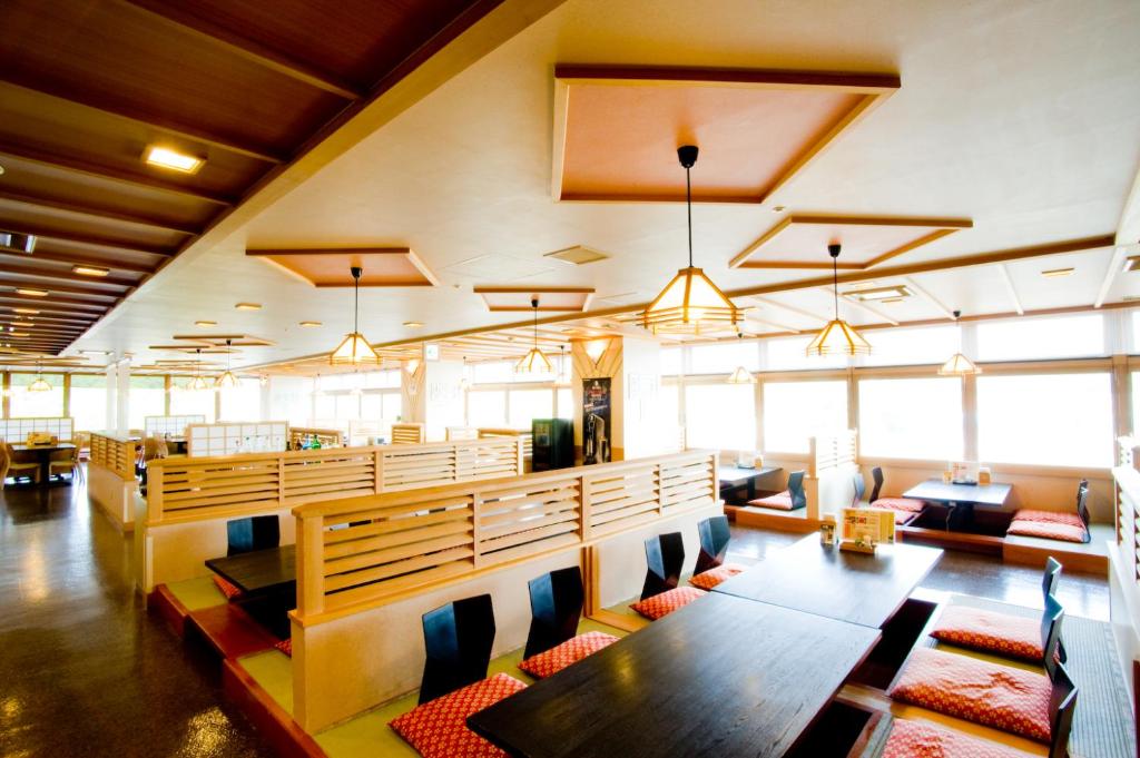 une salle à manger avec tables, chaises et fenêtres dans l'établissement Oehonke, à Kitami
