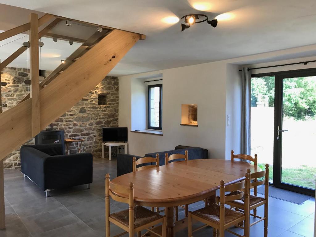 une salle à manger avec une table et des chaises en bois dans l'établissement Les gîtes du Plec - Piscine, à Locoal-Mendon