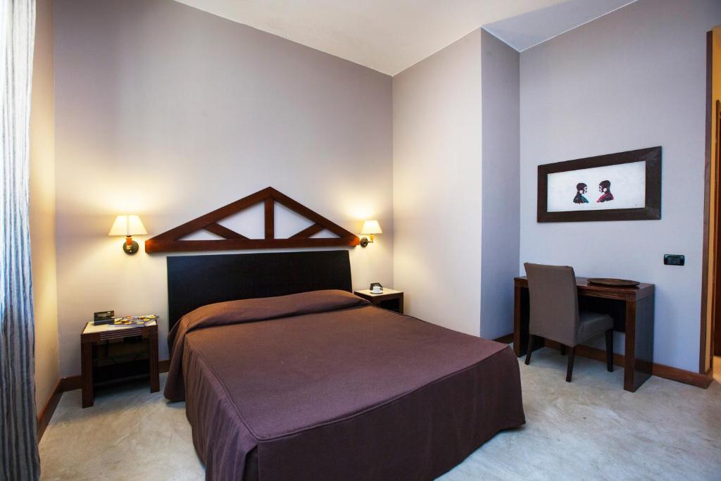 une chambre avec un lit, un bureau et une chaise dans l'établissement Villa Sole, à San Vito Lo Capo