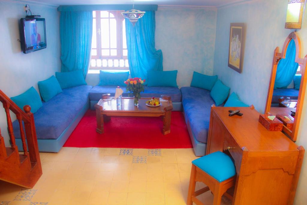un salon avec un canapé bleu et une table dans l'établissement Palais Des Remparts, à Essaouira