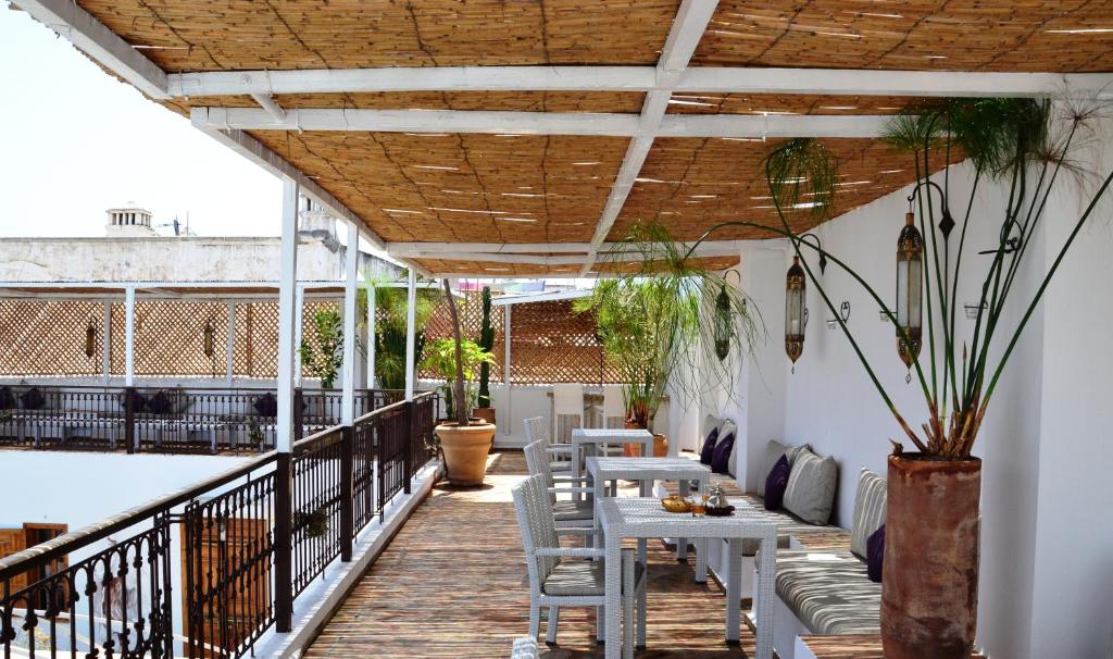 un patio avec tables et chaises sur un balcon dans l'établissement Riad Kalaa, à Rabat