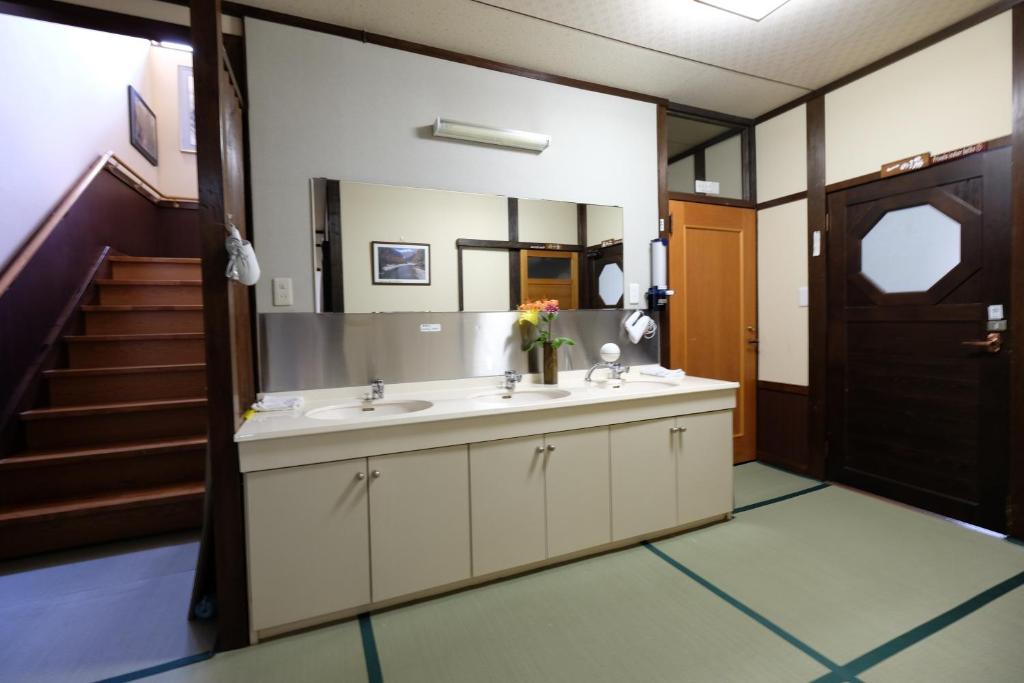 une salle de bain avec un lavabo et un miroir dans l'établissement Tsuyukusa, à Takayama