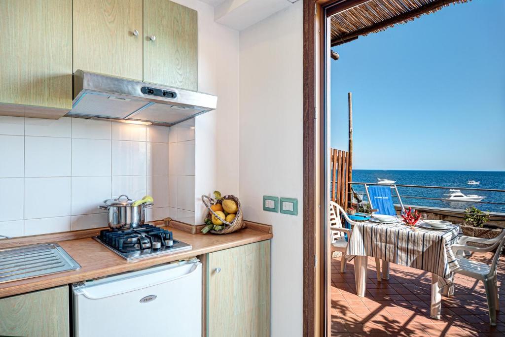 Il comprend une cuisine et un balcon offrant une vue sur l'océan. dans l'établissement Belmare Residence on the beach, à Nerano 32 autres photos