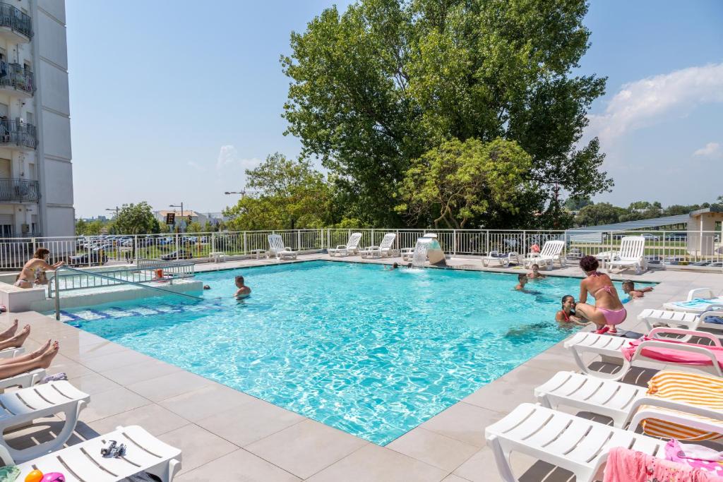 - une piscine avec des chaises et des personnes dans l'établissement Hotel Alla Rotonda, à Lido di Jesolo