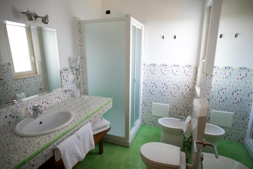 une salle de bain avec deux lavabos et un miroir dans l'établissement Hotel Nike, à Giardini Naxos