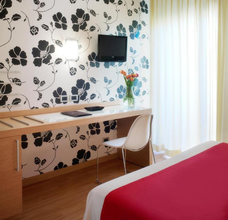 - une chambre avec un bureau, une télévision et un lit dans l'établissement ACasaMia WelcHome Hotel, à Rimini