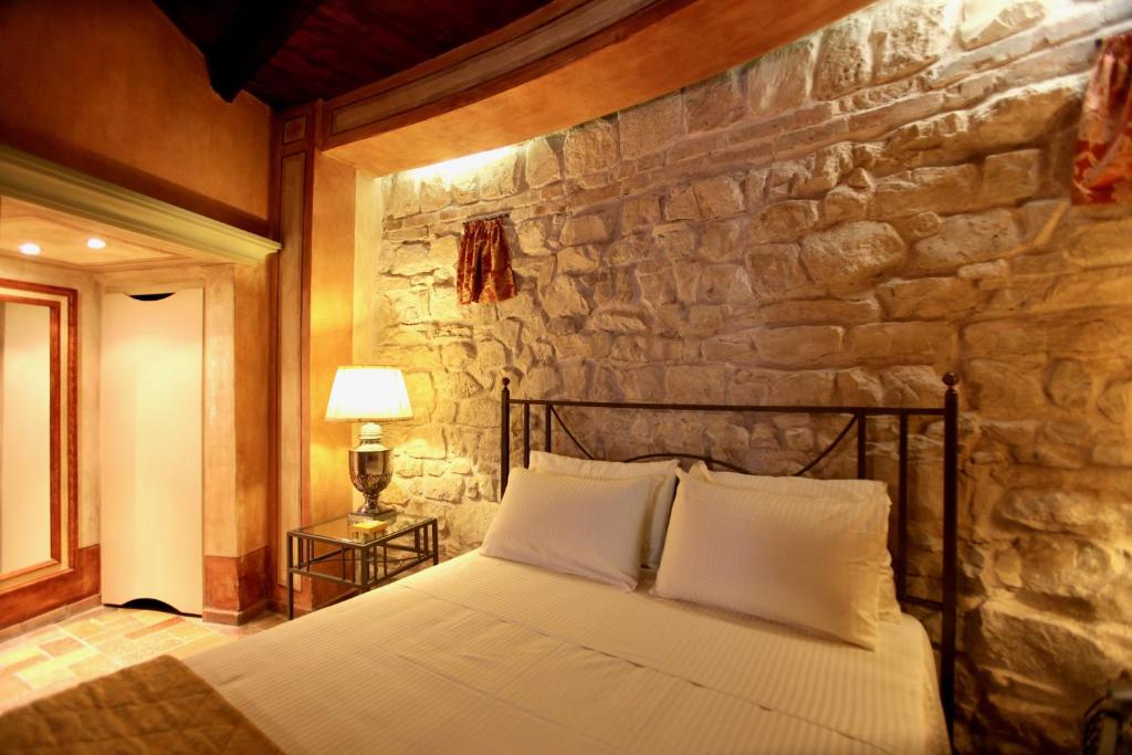 un lit dans une chambre avec un mur en pierre dans l'établissement Fortino Napoleonico, à Ancône 71 autres photos