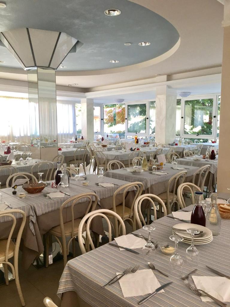 - une salle à manger avec des tables, des chaises et une table dans l'établissement Hotel Monica, à Rimini