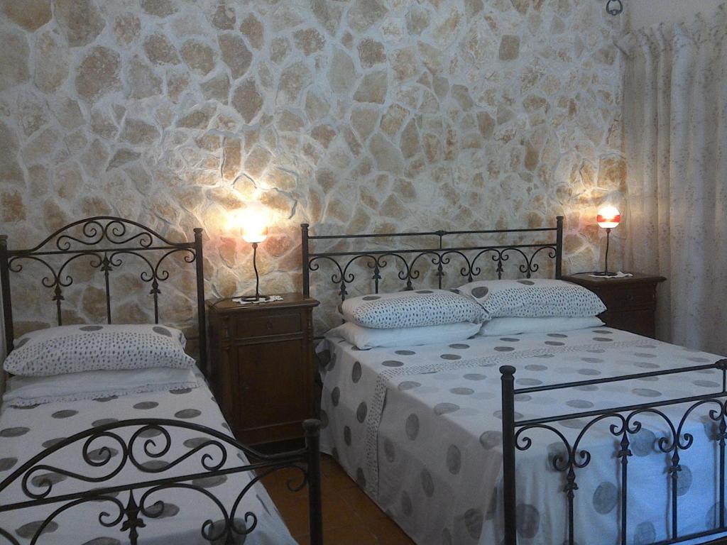 - une chambre avec deux lits et deux lumières sur le mur dans l'établissement Trullocarluccio, à Monopoli