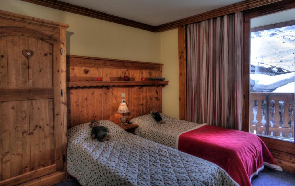 une chambre avec deux lits et une fenêtre dans l'établissement Le Cheval Blanc - Village Montana, à Val Thorens