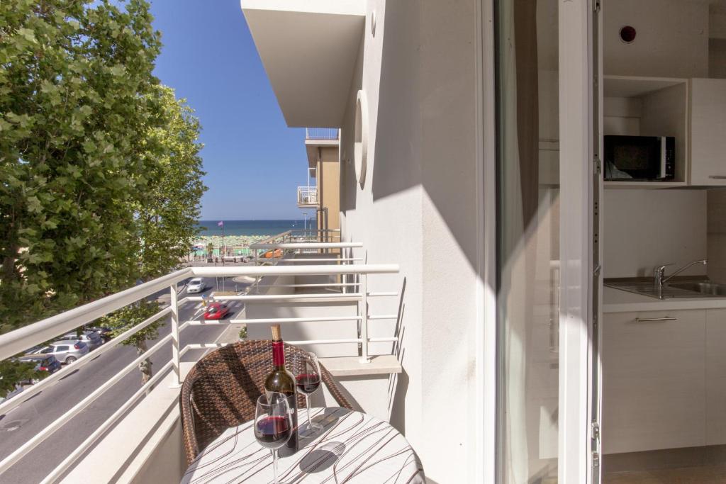 - un balcon avec une table et des verres à vin dans l'établissement Hotel Houston Suites, à Rimini