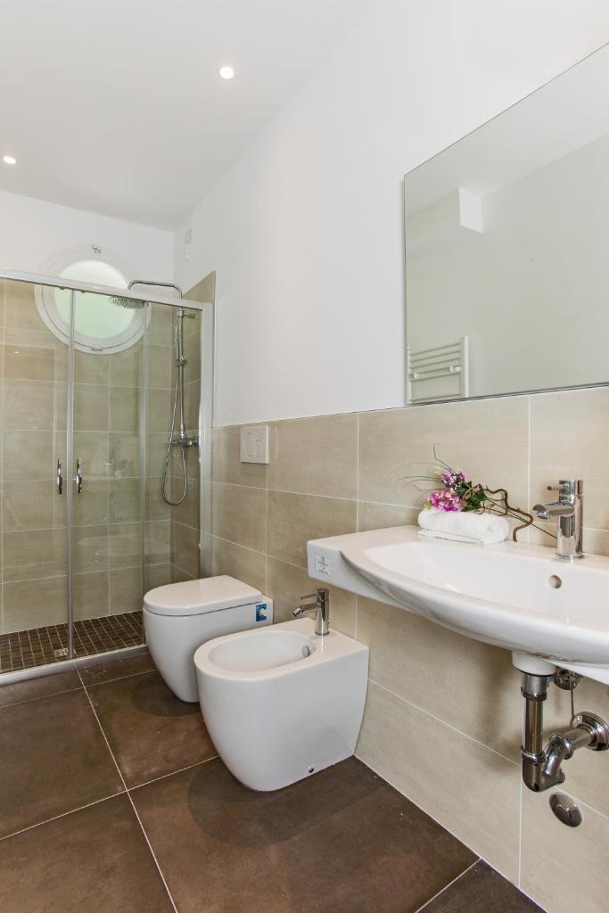 une salle de bain avec toilettes, lavabo et douche dans l'établissement Hotel Houston Suites, à Rimini 52 autres photos