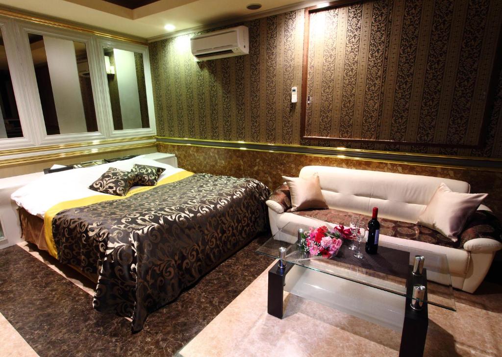 une chambre d'hôtel avec un lit et un canapé dans l'établissement Restay Choshi Aine (Adult Only), à Choshi