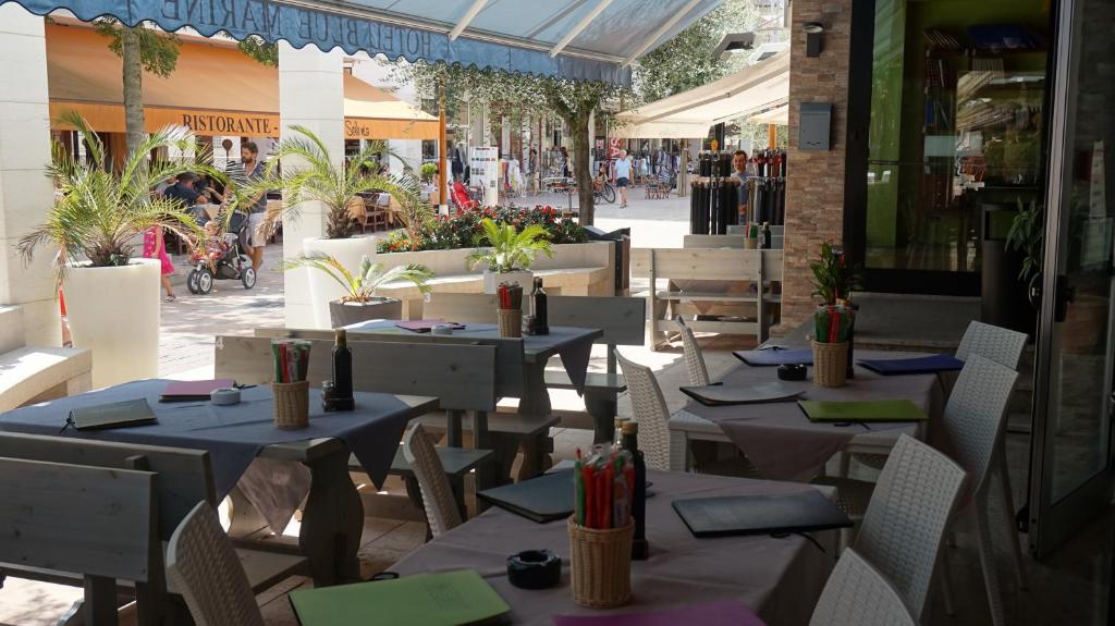 un restaurant avec des tables et des chaises dans une rue dans l'établissement Hotel Blue Marine, à Lignano Sabbiadoro