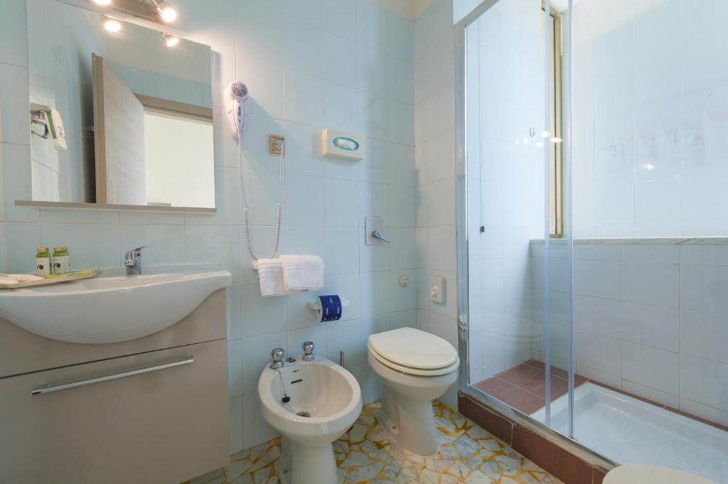 une salle de bain avec toilettes, lavabo et douche dans l'établissement Albergo Battelli Only Adults, à Marina di Pietrasanta