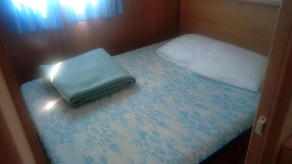 Cette petite chambre comprend un lit et un oreiller. dans l'établissement Camping Du Pont De St Gal, à Saint-Gal-sur-Sioule