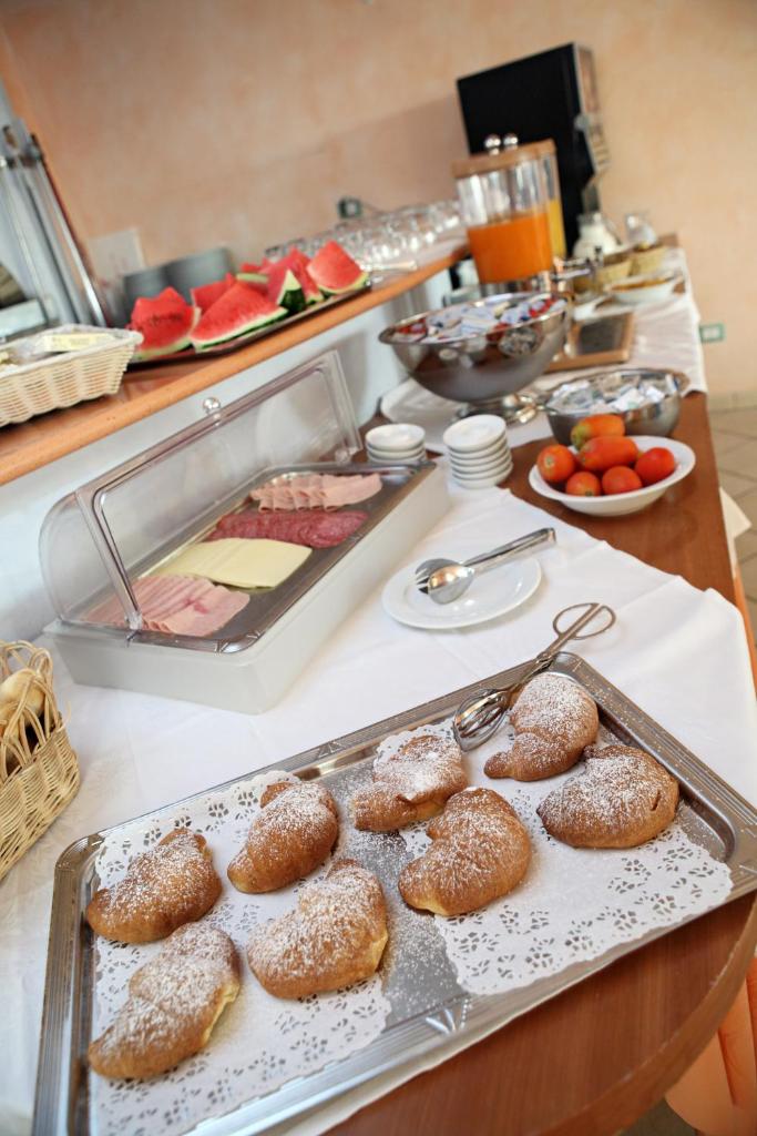 un buffet avec des beignets et d'autres aliments sur une table dans l'établissement Abbazia Club Hotel Marotta, à Marotta