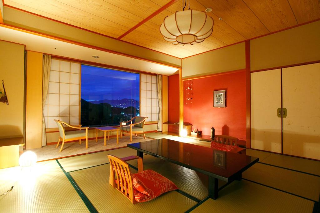 un salon avec une table et une salle à manger dans l'établissement Izu-Nagaoka Hotel Tenbo, à Izunokuni