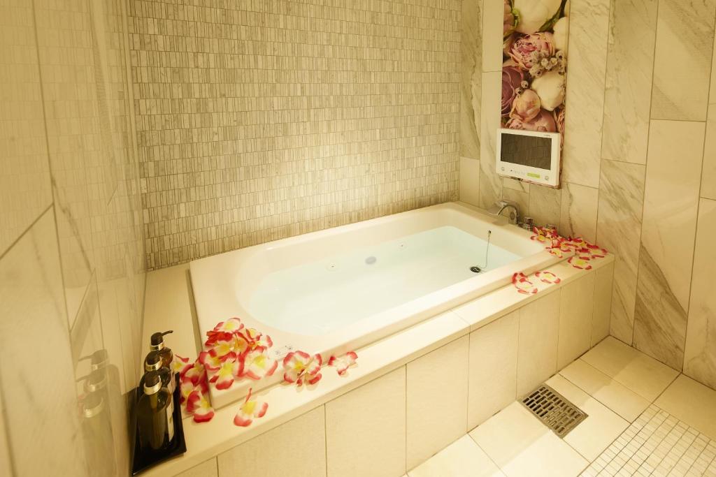 La salle de bains est pourvue d'une baignoire fleurie. dans l'établissement Hotel Venus Neo, à Nagoya