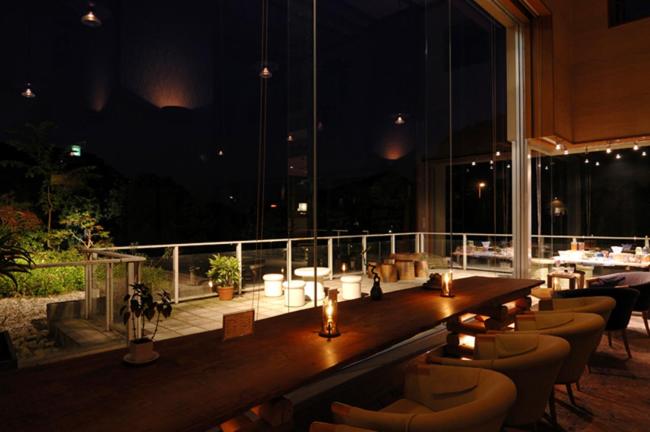 un restaurant avec un bar doté de chaises et de lumières dans l'établissement Izu-Nagaoka Hotel Tenbo, à Izunokuni