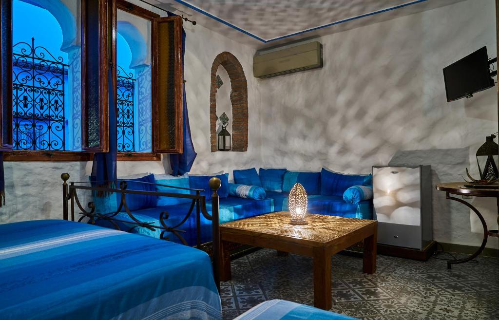 - une chambre avec un lit bleu et une table dans l'établissement Dar Yakout, à Chefchaouen