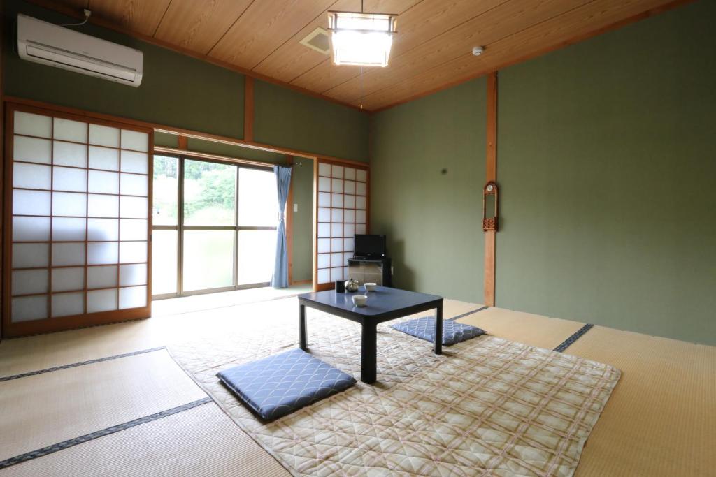 une chambre avec une table au milieu d'une pièce dans l'établissement Minshuku Shiroyama, à Taketa