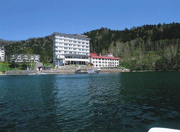 un bâtiment sur la rive d'une grande étendue d'eau dans l'établissement Shikaribetsu Kohan Onsen Hotel Fusui, à Shikaoi
