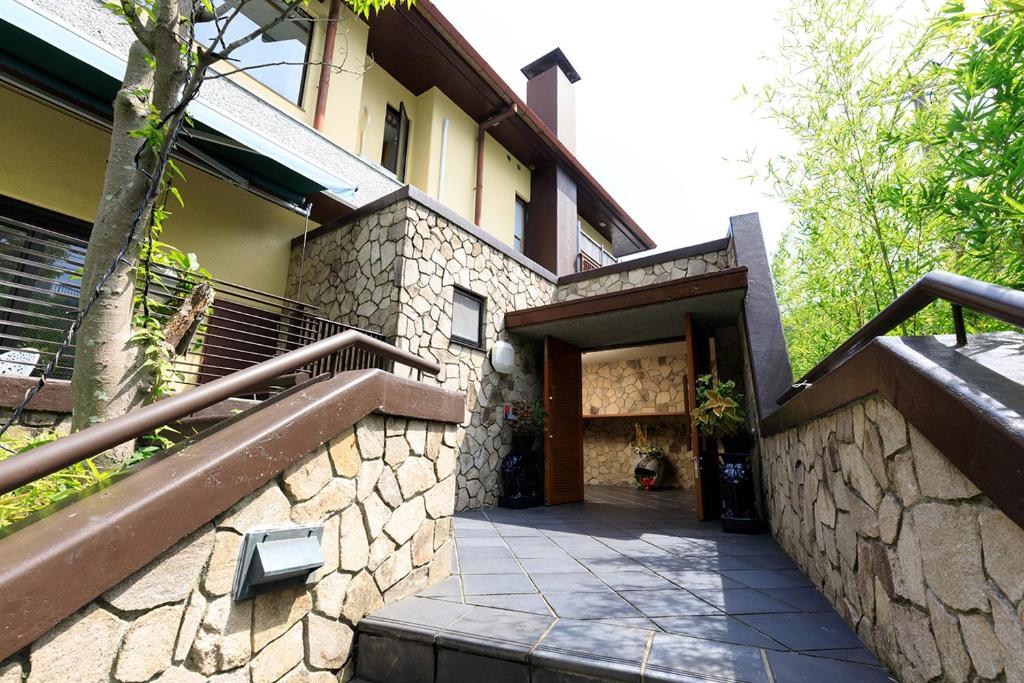 une maison avec un mur en pierre et un escalier dans l'établissement 雅竹Miyabitake, à Yugawara