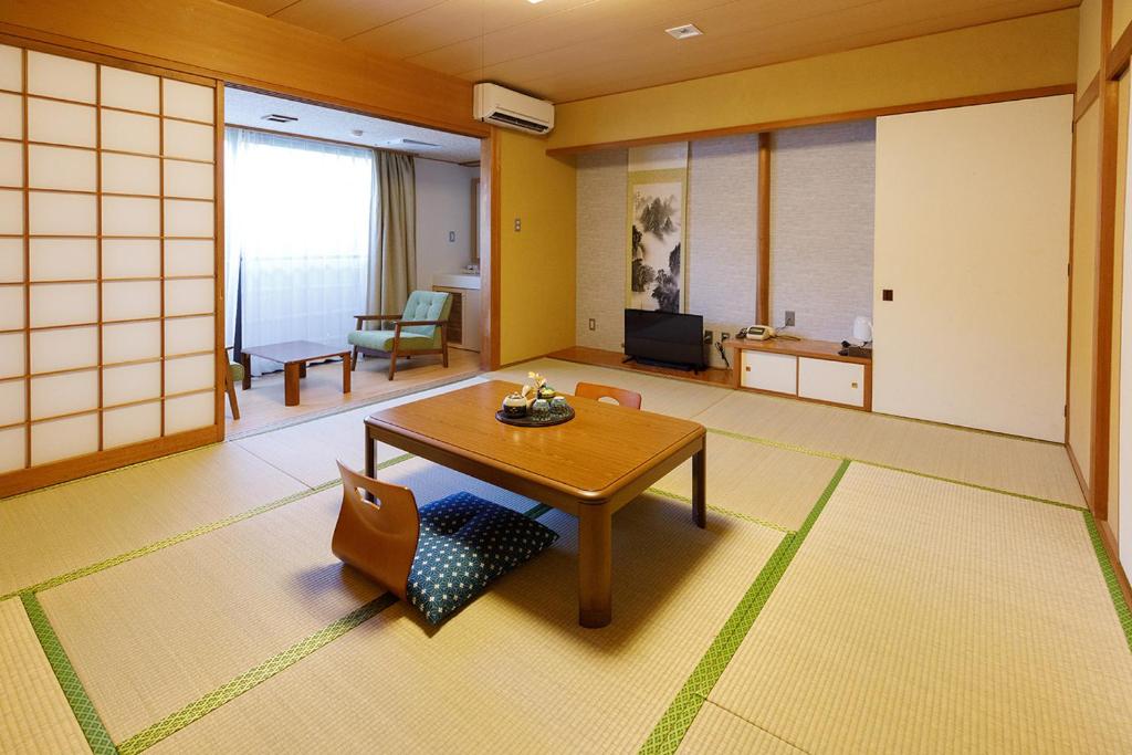 une pièce avec une table et des chaises dans une pièce dans l'établissement 雅竹Miyabitake, à Yugawara