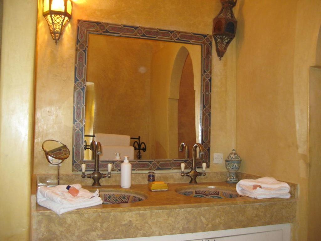 une salle de bain avec un lavabo avec un grand miroir dans l'établissement Riad Ifoulki, à Marrakech